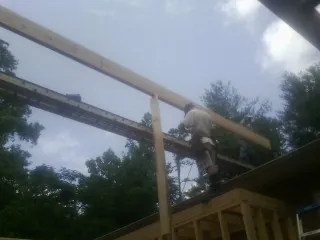 Carpenter setting a ridge beam over a new addition frame — Ice Dam Removal by Roofing Brothers in Westbury
