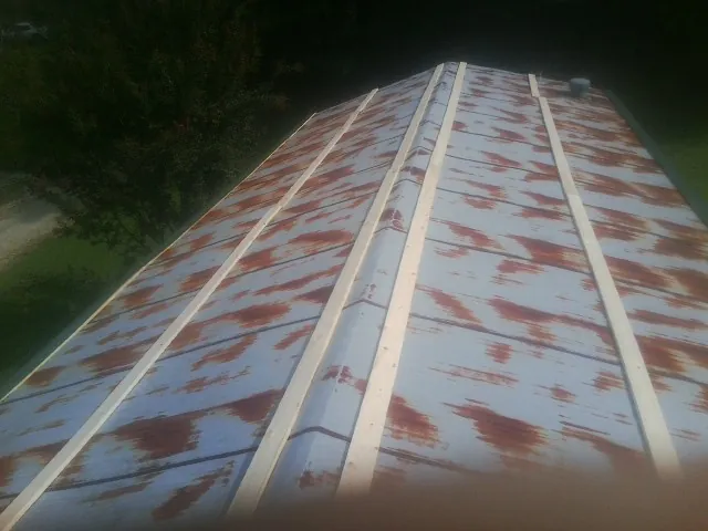 Rusted metal roof panels with new wood purlins before replacement — Storm Damage Roof Repair in Westbury by Roofing Brothers