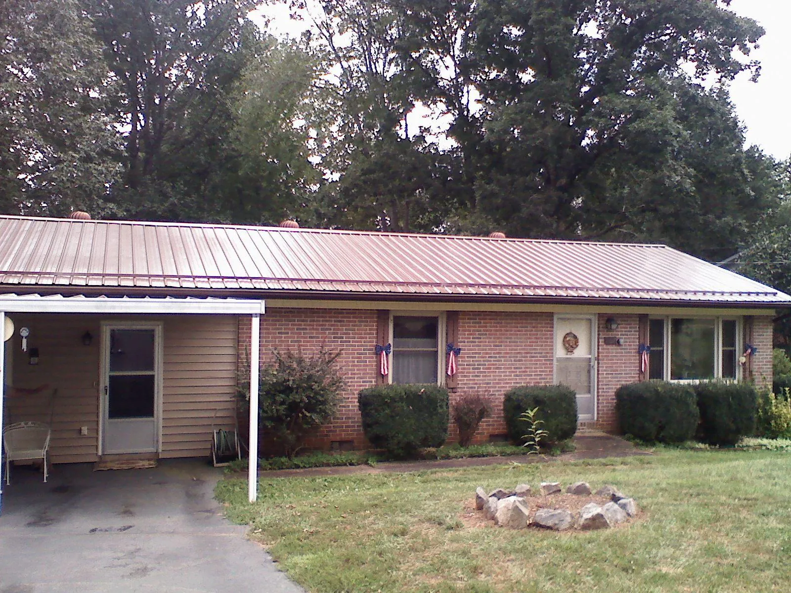 Bronze metal roof and carport on a brick ranch home — Roof Repair work by our crew in Westbury